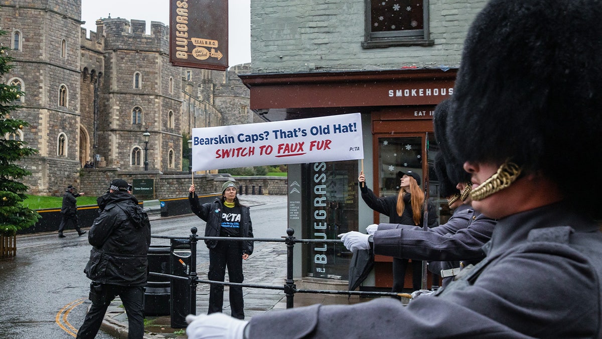 PETA supporters hold a banner reading 'Bearskin Caps? Thats Old Hat!