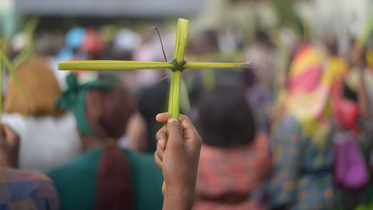 Christians in Nigeria hold up crosses made from palm branches