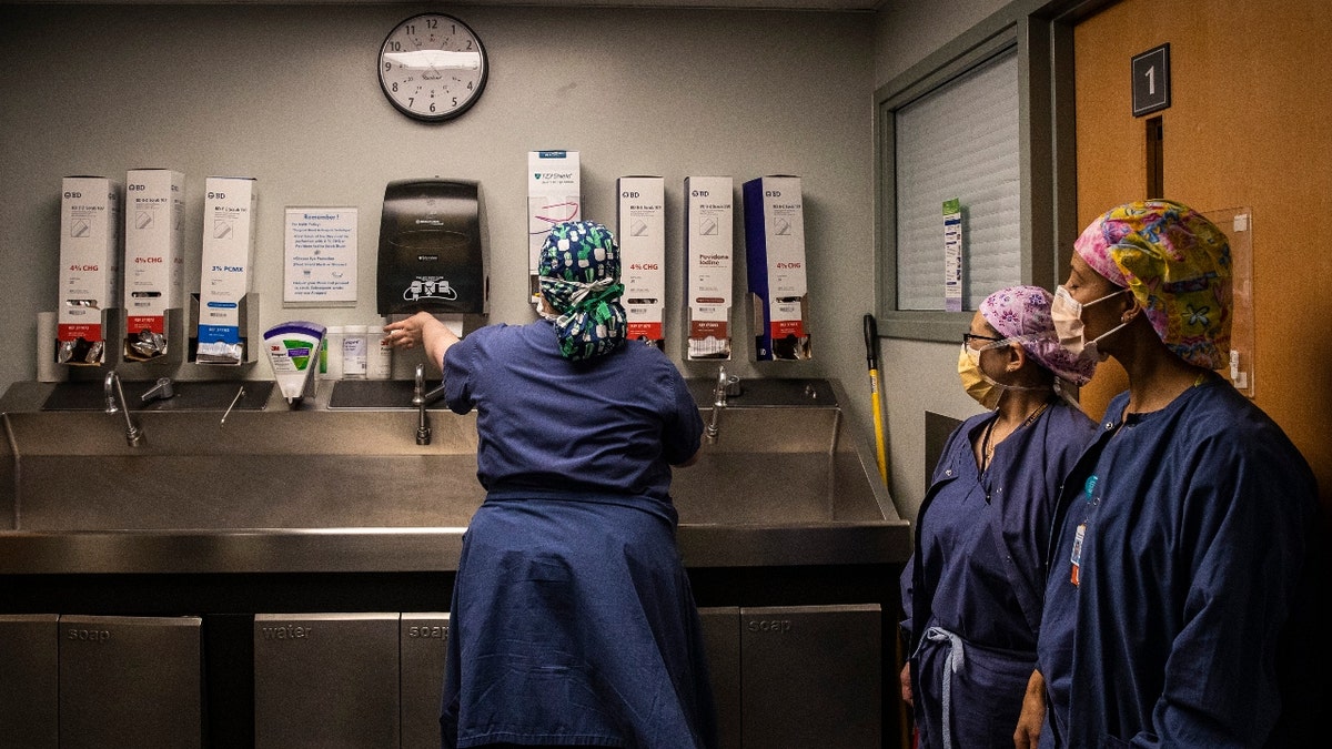 Surgical Technicians wash their hands after exiting an operating room at Newton-Wellesley Hospital in Newton, MA on April 22, 2022.