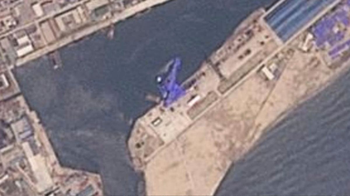 satellite  shows the destroyer covered in a blue tarp