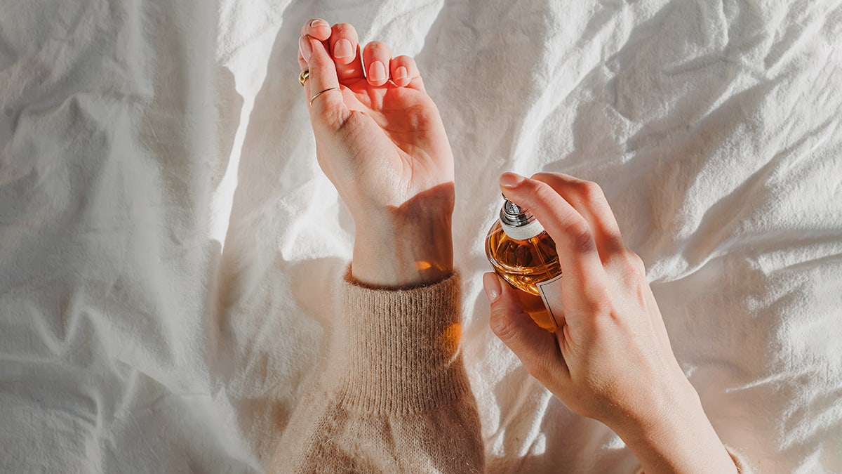 Hands spraying perfume