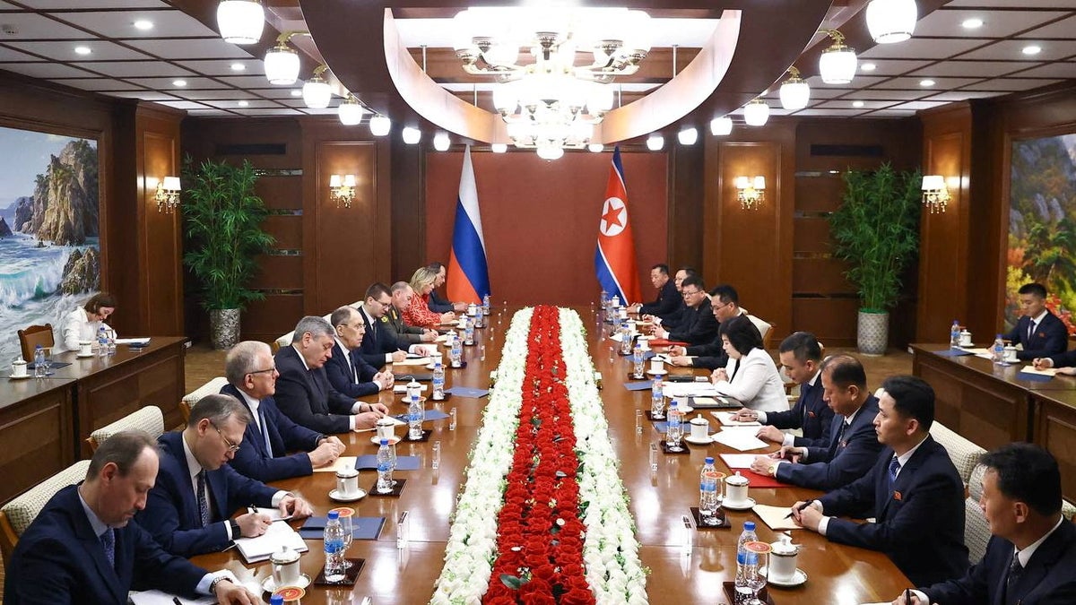 Sergei Levrov at a table with officals in North Korea