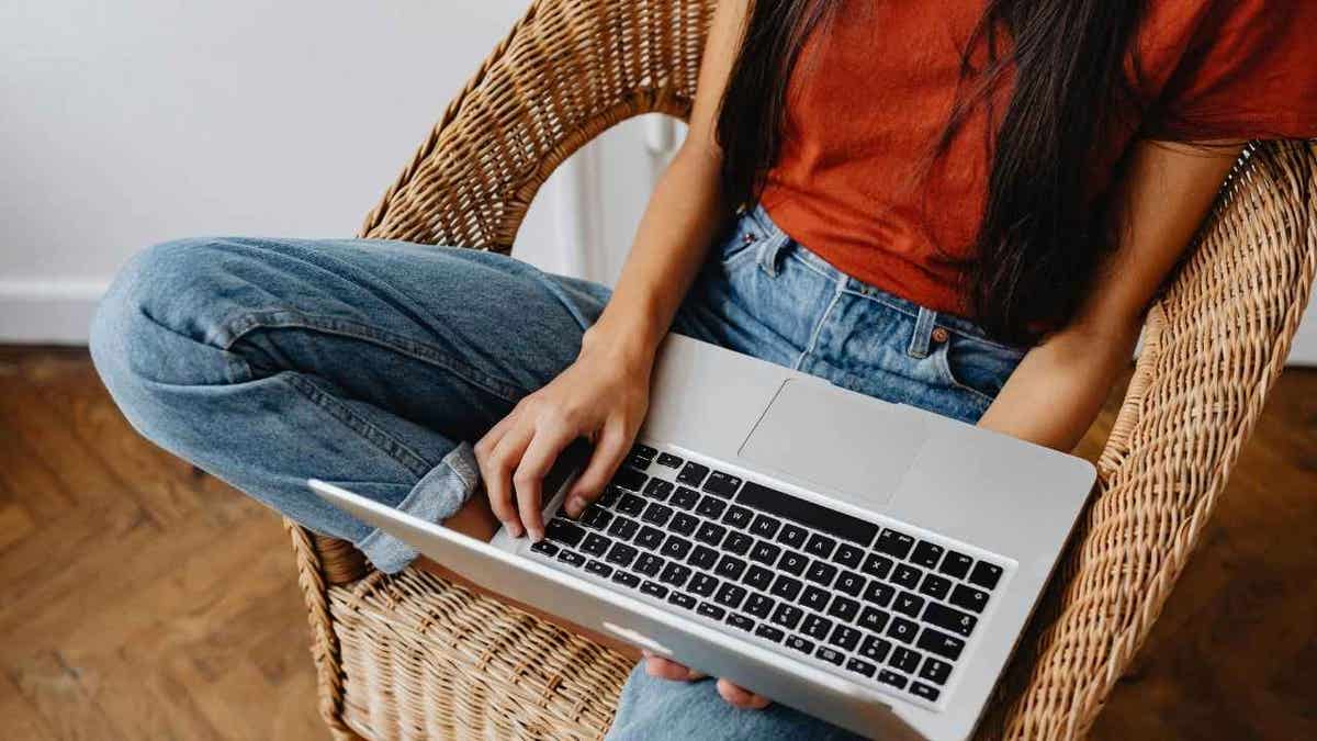 Woman using laptop in chair