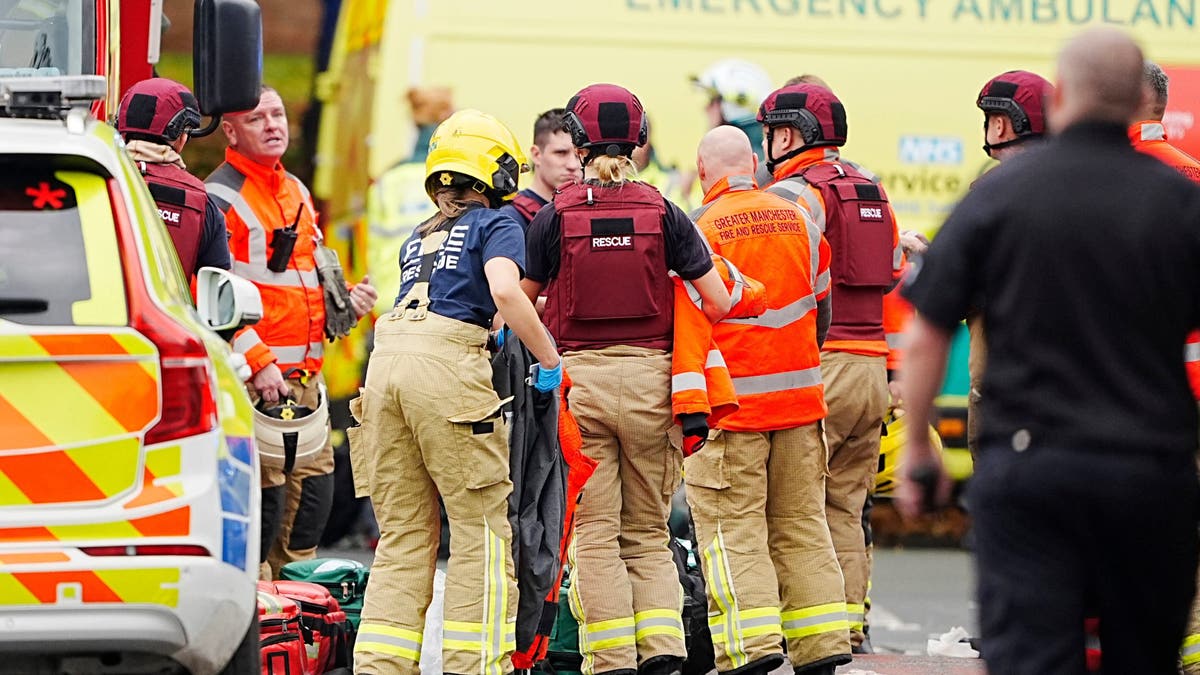 Firefighters and paramedics respond outside Heaton Park Hebrew Congregation Synagogue in Manchester, England, Thursday, Oct. 2, 2025, after a car was driven into pedestrians and a man was stabbed. Police said four people were injured and the suspect was shot by officers.
