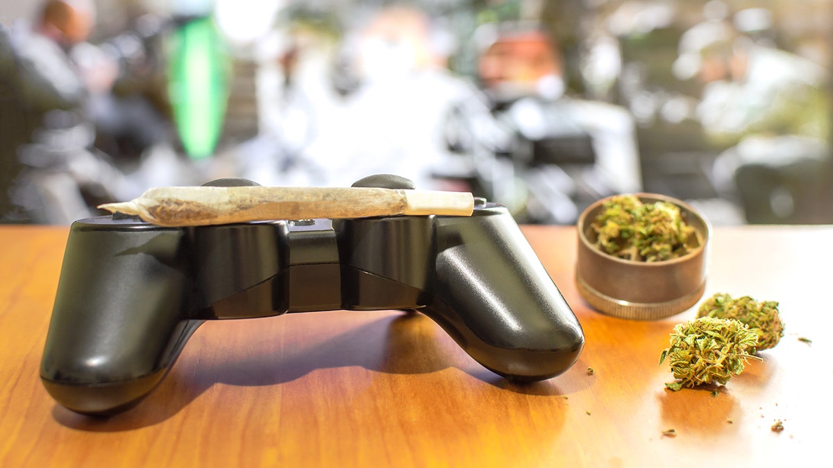 a marijuana joint on top of a gaming controller
