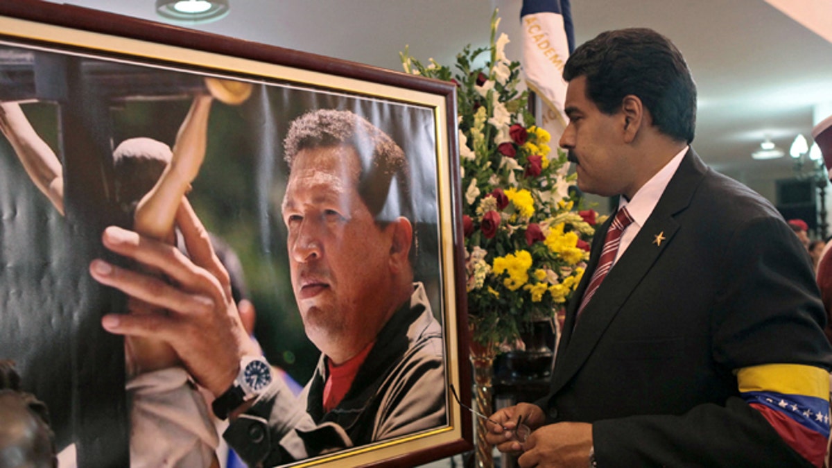 FILE -March 8, 2013 file photo released by Miraflores Press Office: Venezuela's President Nicolas Maduro stands in front of a portrait of Venezuela's late President Hugo Chavez. (AP Photo/Miraflores Press Office, File)