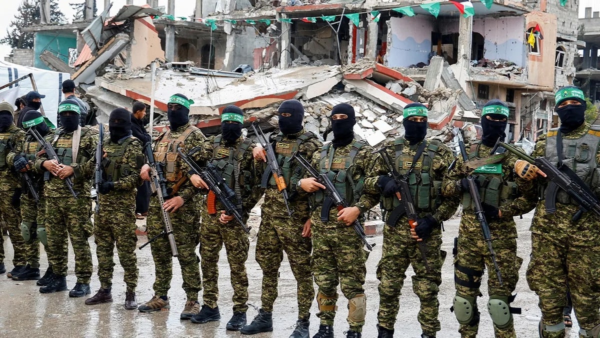Hamas terrorists stand in front of rubble in Rafah, Israel