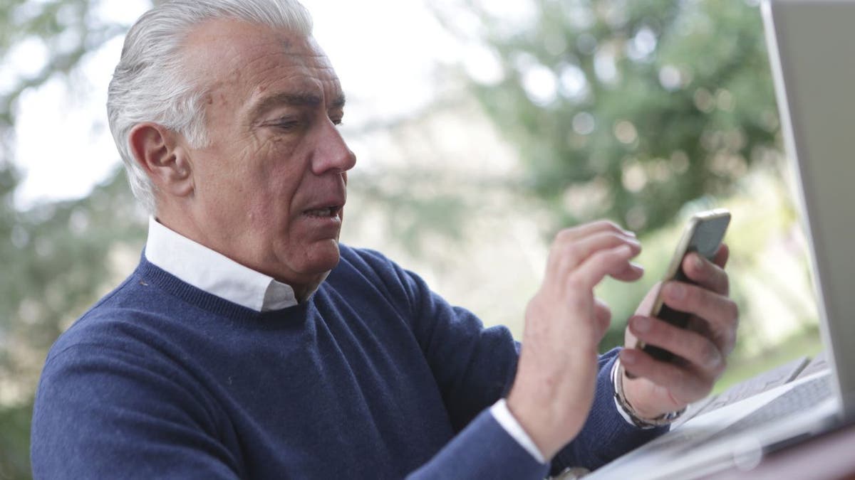 Elderly man using his phone.