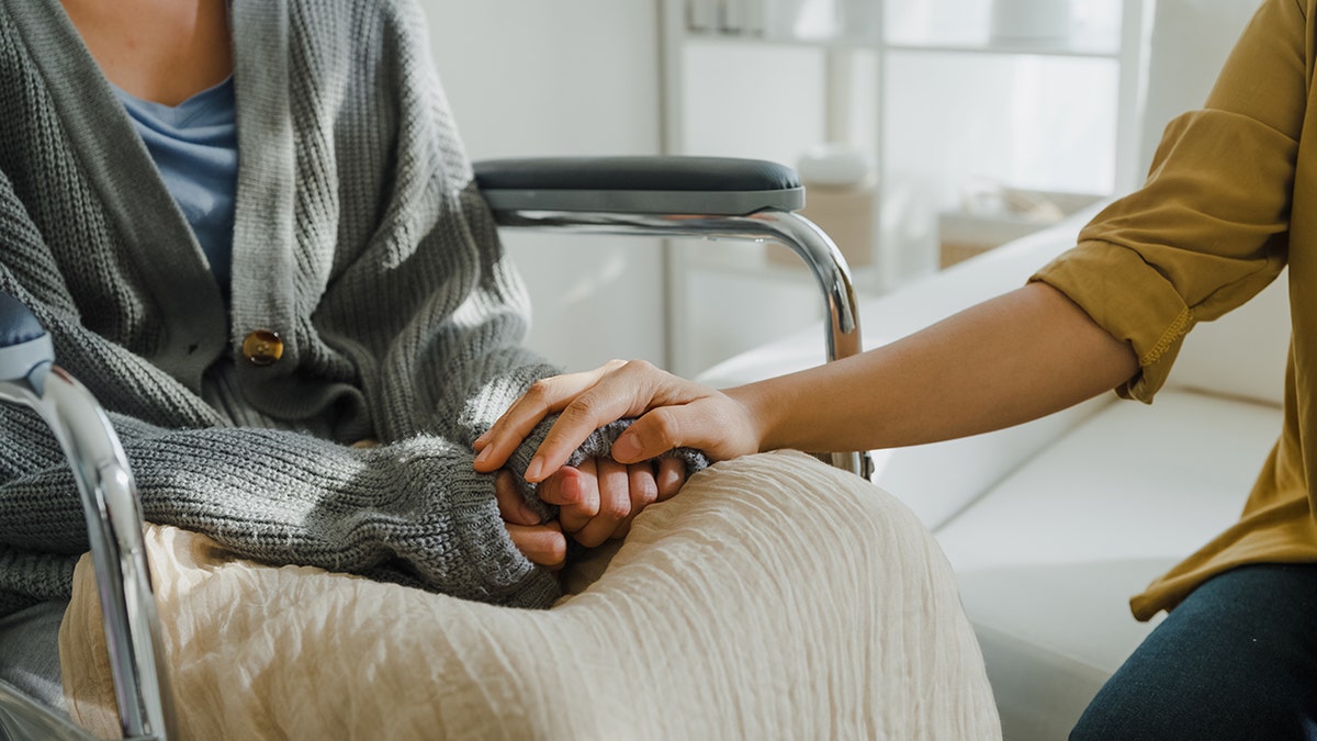 Closeup of young people holding hands in hospital