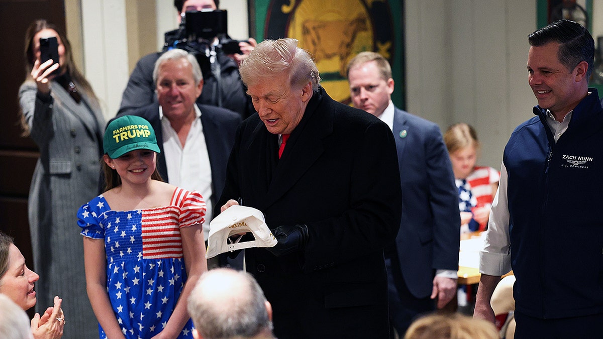 President Trump signs hat for supporter