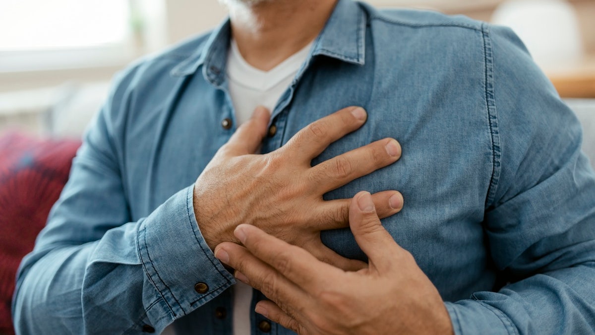 Man holding chest with heart pain