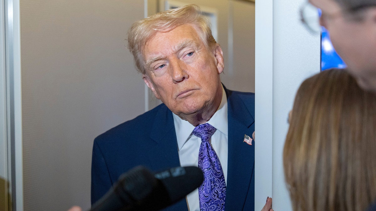 The president addresses journalists aboard Air Force One during a return flight.