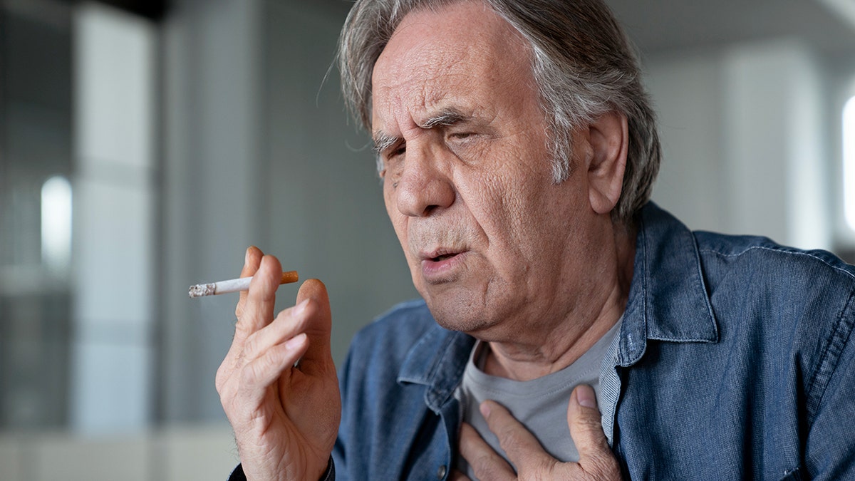 Older gentleman smoking a cigarette and coughing