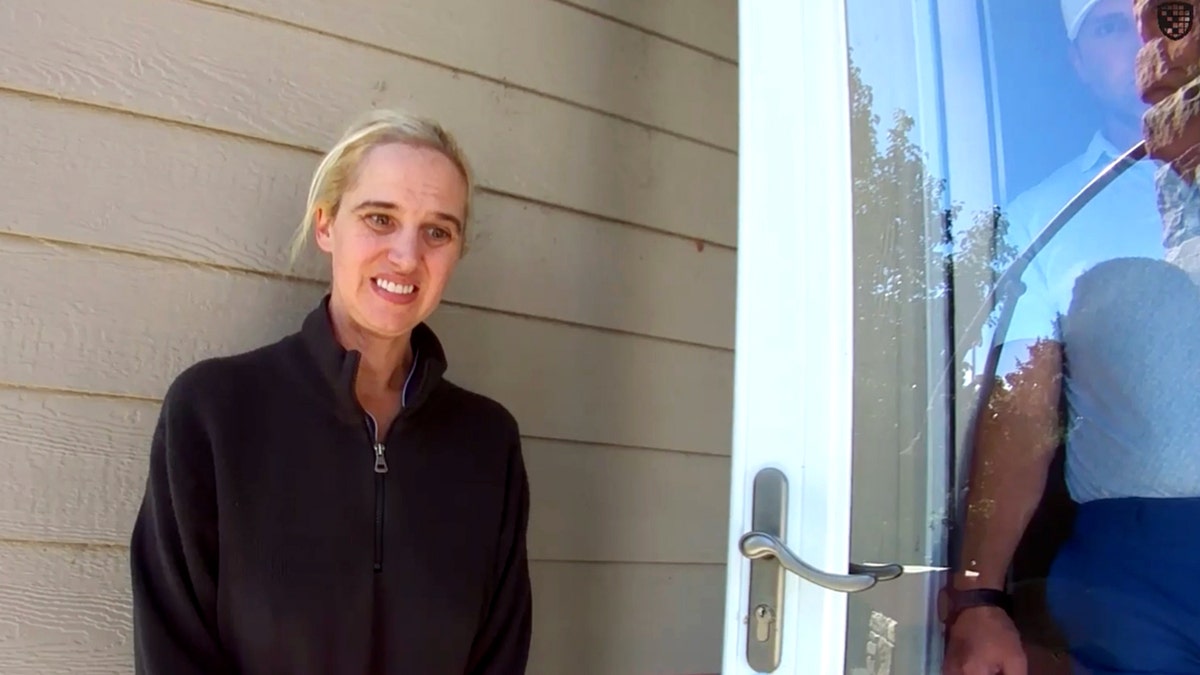 Chrisanna Elser stands on her front porch, talking to police.