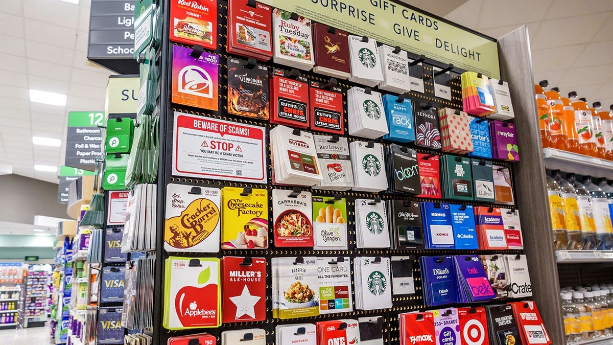 A wall of gift cards in a store is shown.