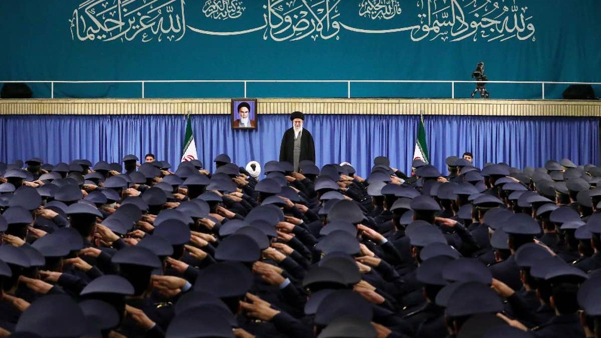 Supreme Leader Ayatollah Ali Khamenei standing as air force commanders salute in Tehran