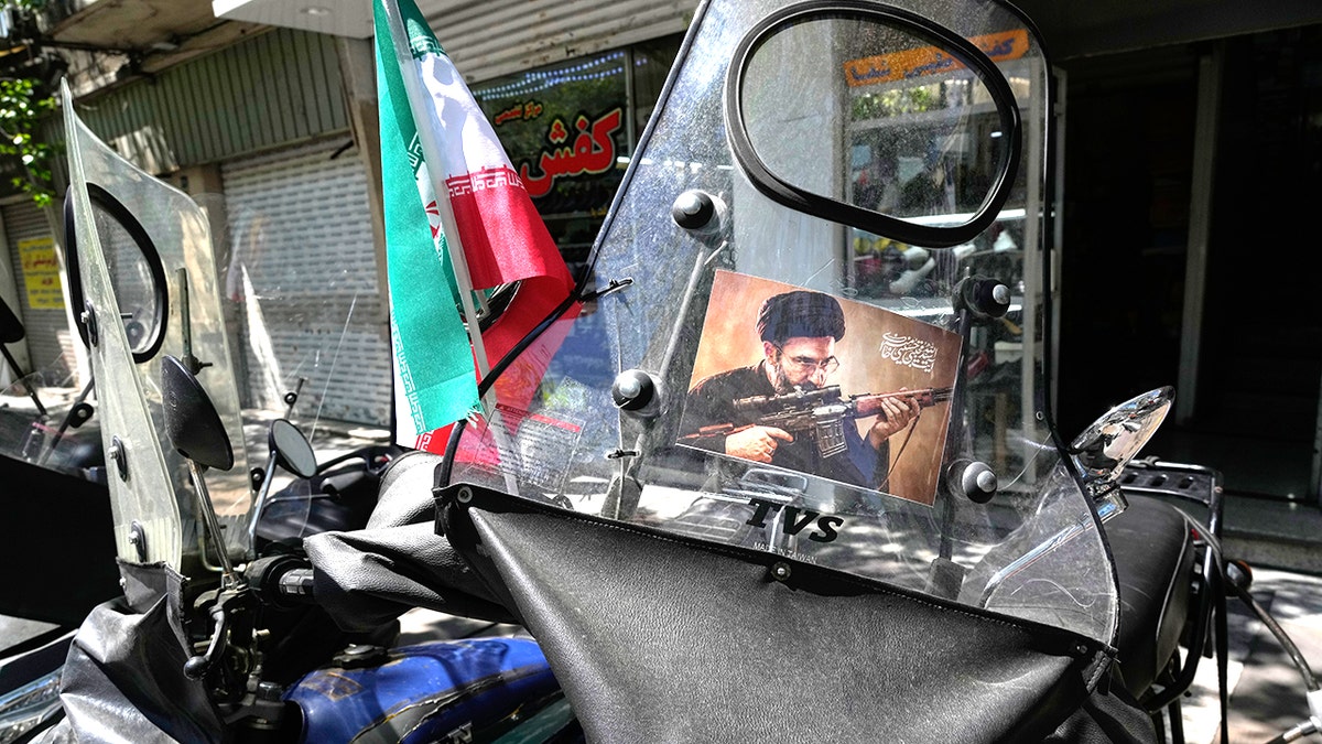 A poster of Ayatollah Mojtaba Khamenei pasted on a motorcycle windshield in Tehran