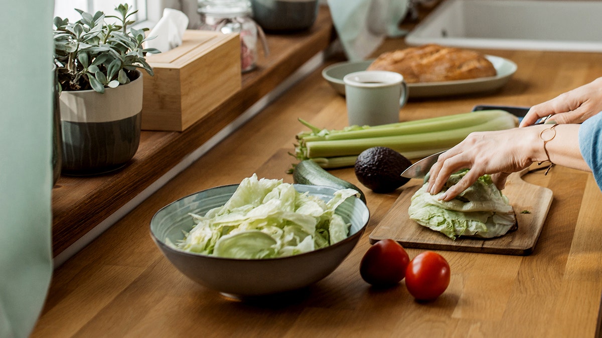 Woman making salad in a home kitchen