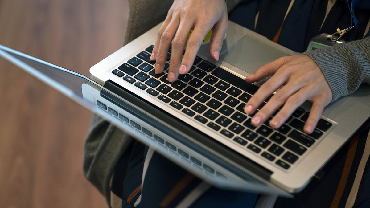 Woman typing on a laptop keyboard
