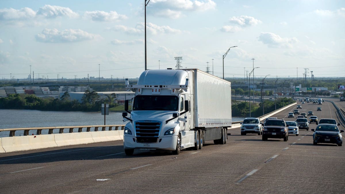A fully autonomous semi-truck travels on the highway.