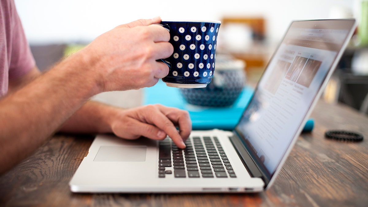 Person typing on a laptop keyboard.