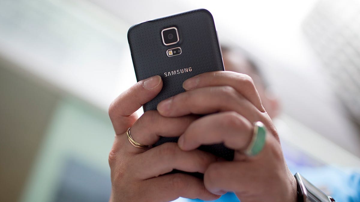 Woman typing on her Samsung smartphone.
