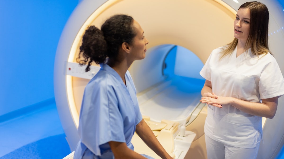 Woman discussing MRI with technician