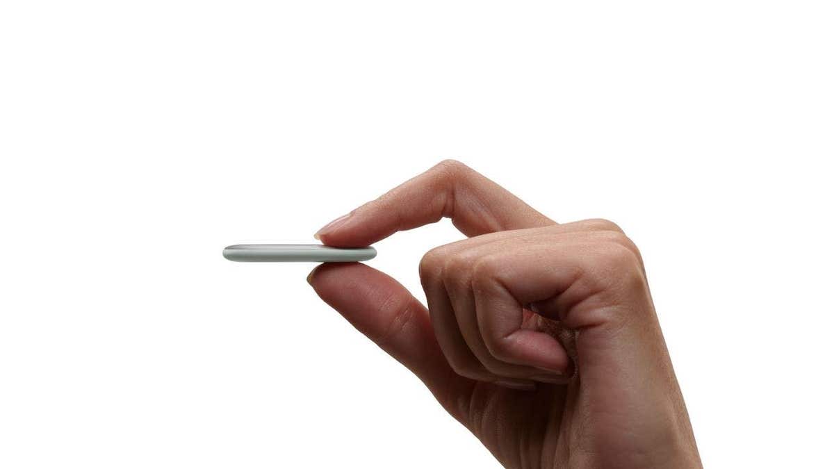 A person holding a Google Pixel Tag