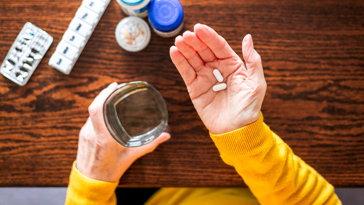 Woman holding two pills