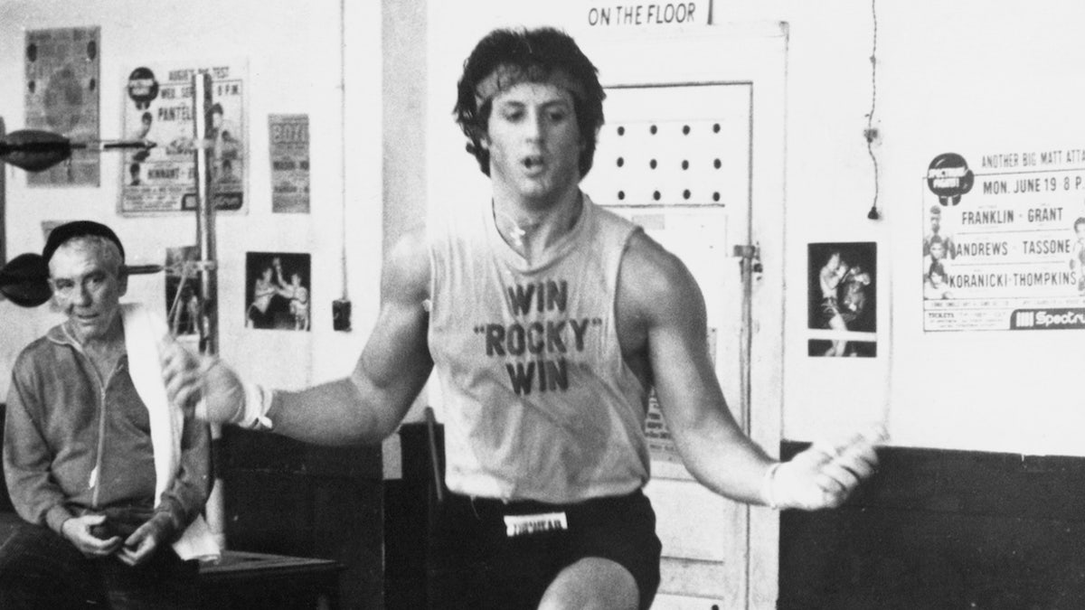Training for a heavy weight title fight, Rocky Balboa (Sylvester Stallone) skips rope under the watchful eye of his manager, Mickey (Burgess Meredith), and trainer Johnny (Stuart K. Robinson) in Rocky II. (Photo by �� John Springer Collection/CORBIS/Corbis via Getty Images)
