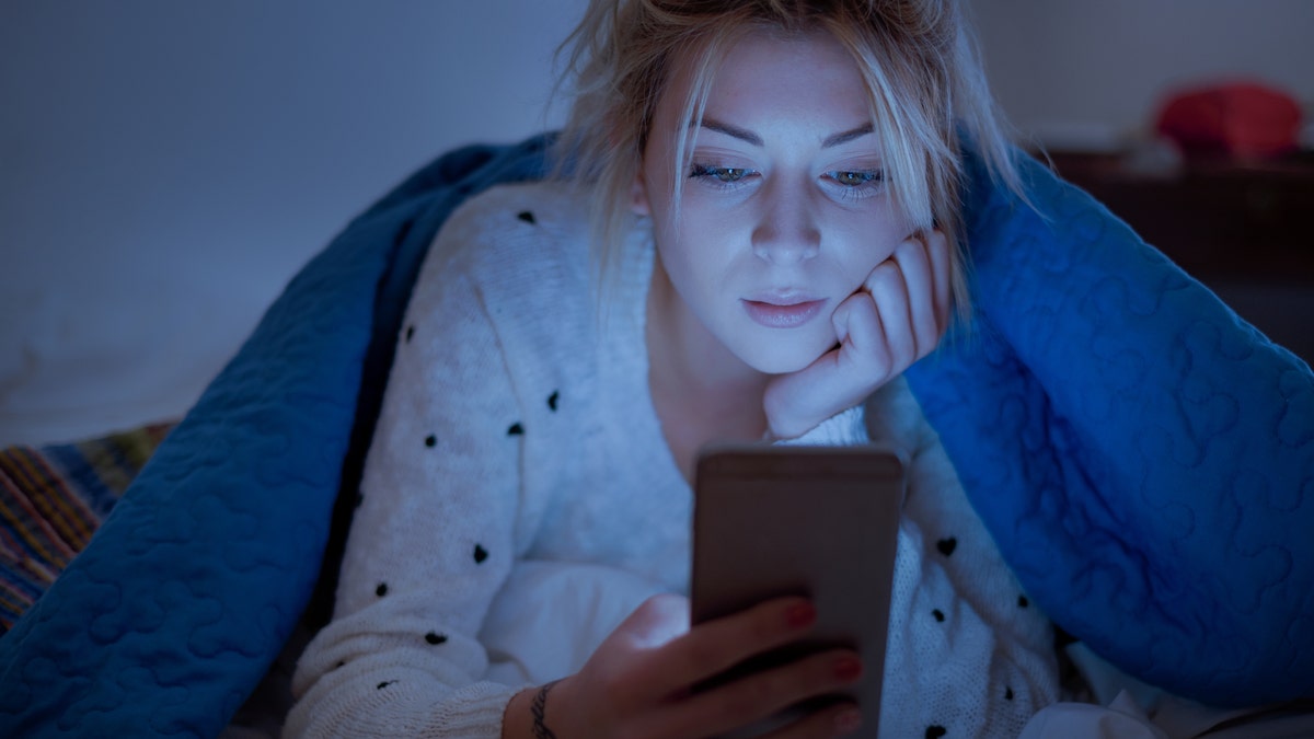 woman on phone in bed