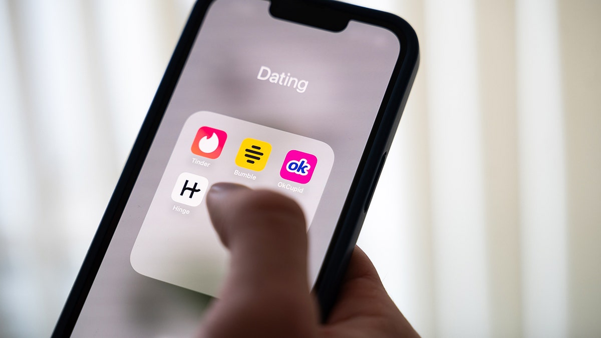 Person selecting a dating app on their phone.