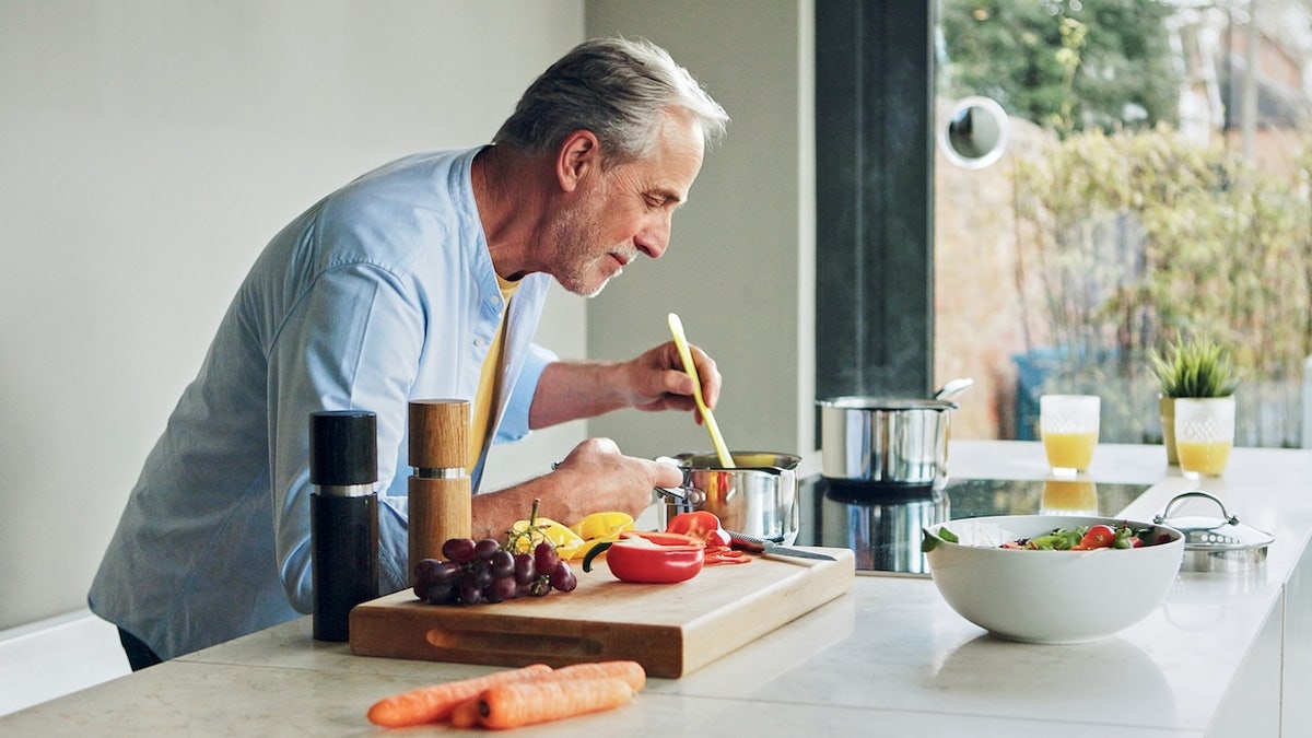 Cooking, kitchen and senior man for lunch, supper and prepare healthy dinner in home. Retirement, food and mature person with natural ingredients, cutting vegetables and organic meal for nutrition