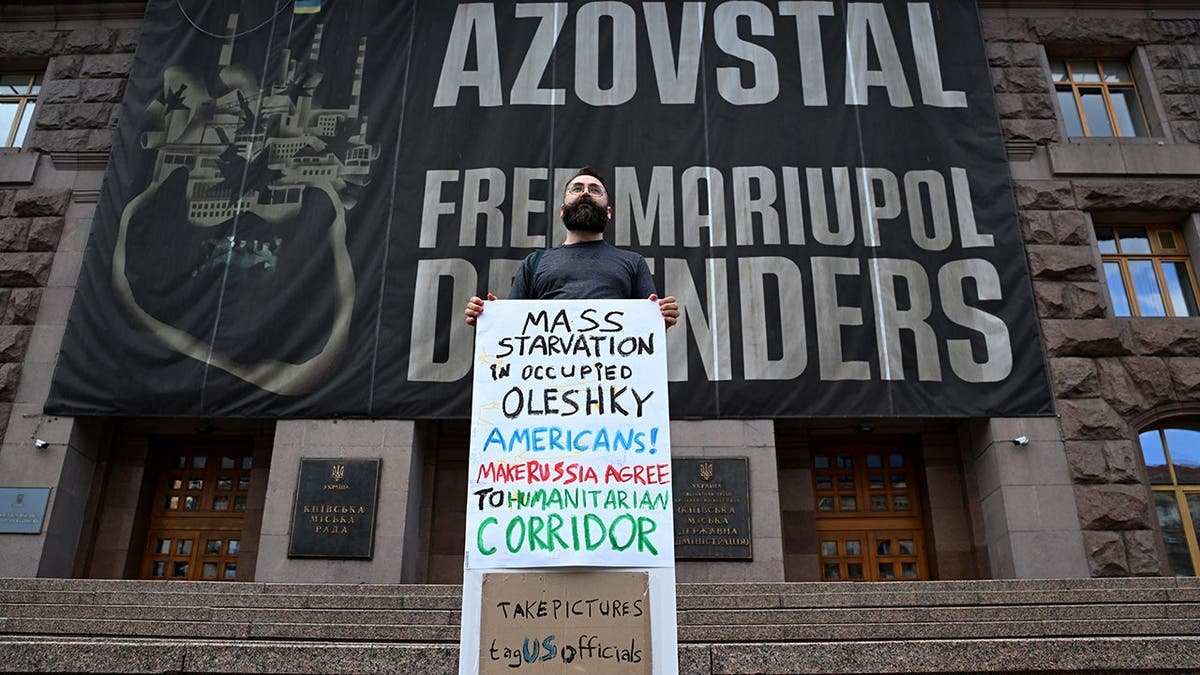 Man holds a placard reading 