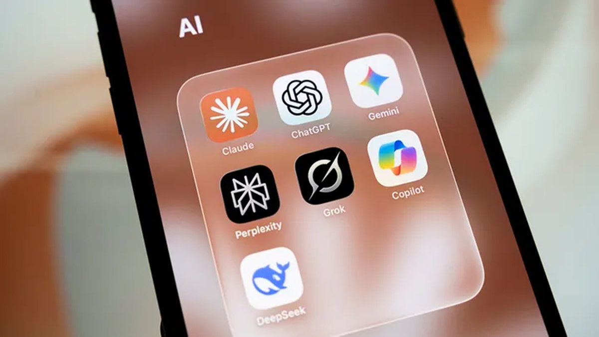 A smartphone screen displays a folder containing AI applications Claude, ChatGPT, Gemini, Perplexity, Grok, Copilot and DeepSeek. (Samuel Boivin/NurPhoto via Getty Images / Getty Images)